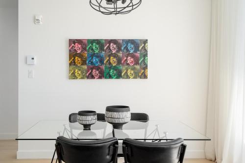 a dining room with a glass table and chairs at Le Se7t Penthouses in Montréal