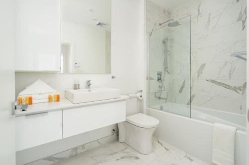 a bathroom with a toilet and a sink and a shower at Le Se7t Penthouses in Montréal