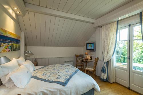 a bedroom with a bed and a table and a window at Villa Cécile in Yvoire