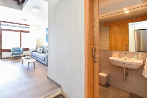 bagno con lavandino e soggiorno di BeachFront Suites Morea Puerto Rico by VillaGranCanaria a Puerto Rico de Gran Canaria