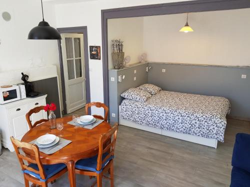 a small room with a table and a bed at l'Avant Garde, dormir dans un bâtiment classé au patrimoine mondial de l'UNESCO in Blaye