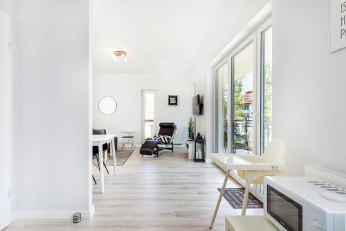 a living room with white walls and wooden floors at Apartament Nowa Flotylla by Renters in Świnoujście