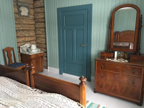 a bedroom with a bed and a mirror and a dresser at Skjeggestad Gjestehus in Ringebu