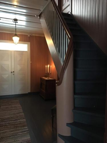 a hallway with a staircase and a door with candles at Skjeggestad Gjestehus in Ringebu
