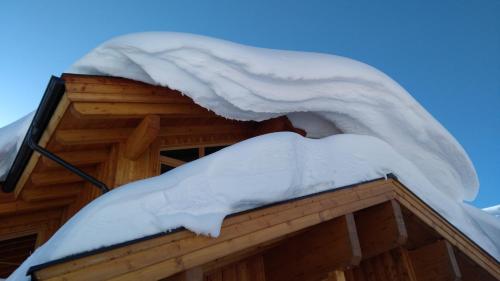 a snow covered roof of a log cabin at Clubhotel Hinterthal Am Florysee 6 in Hinterthal