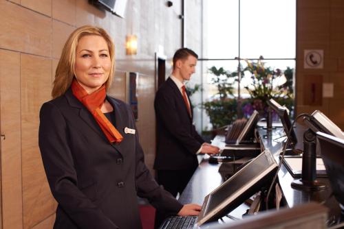 een vrouw die voor een computer in een kantoor staat bij Clayton Hotel Dublin Airport in Cloghran