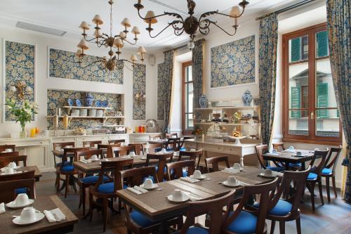 um restaurante com mesas e cadeiras de madeira numa sala em FH55 Hotel Calzaiuoli em Florença