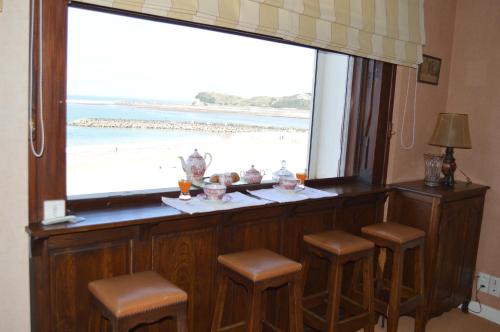 een bar met een raam met uitzicht op het strand bij Ayenac in Saint-Jean-de-Luz