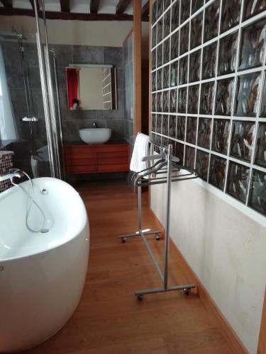 une salle de bain avec une baignoire blanche et un lavabo dans l'établissement Chambres d'Hôtes La Bosquetière, à Maresché