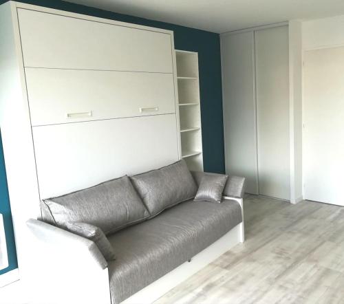 a living room with a leather couch and shelves at Appartement 4 couchages, 100 mètres de la mer ! in Les Sables-dʼOlonne