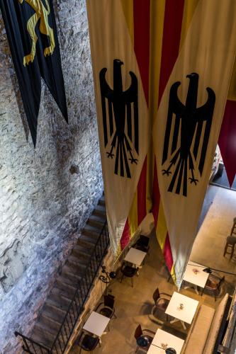two flags are hanging in a room with tables and chairs at Parador de Hondarribia in Hondarribia