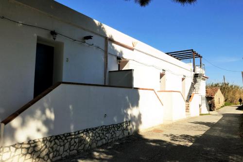 ein weißes Gebäude mit einer Seitentür in der Unterkunft Agriturismo Aiolia - Panorama Eolie in Mongiove