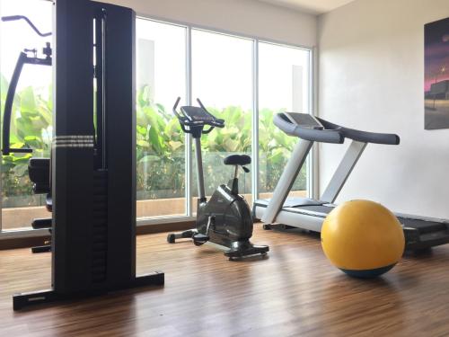 a gym with treadmills and exercise equipment in front of a window at Asialink Easy by Prasanthi in Batam Center