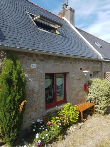 a stone house with a window and a bench at PENTY SERVANE in Loctudy