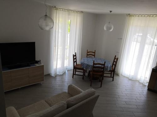 ein Wohnzimmer mit einem Sofa, einem Tisch und einem TV in der Unterkunft Levanto House in Levanto