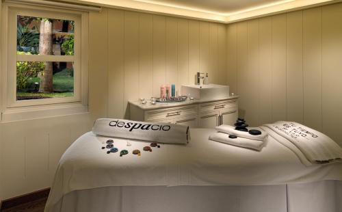 a bathroom with a bed with a sink and towels at H10 Costa Adeje Palace in Adeje