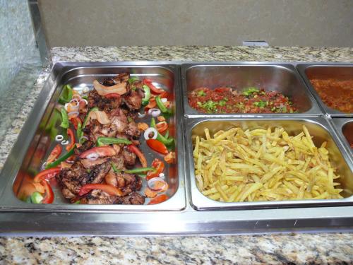 two metal trays of food on a counter at Tiffany Diamond Hotels Ltd - Indira Gandhi street in Dar es Salaam