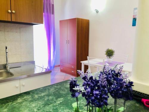 a kitchen with purple flowers sitting on the floor at Carlottas'home in Catania