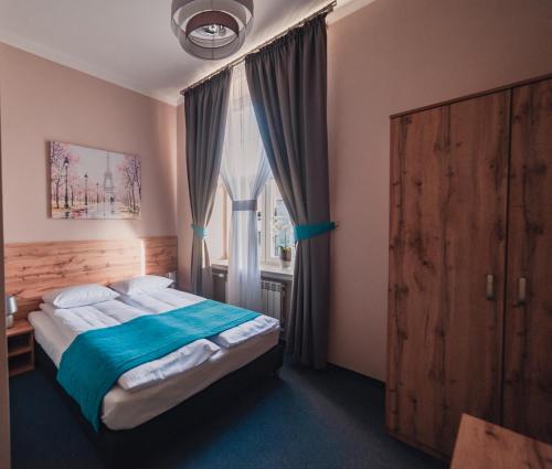 een slaapkamer met een bed en een groot raam bij Villa Centro in Oświęcim