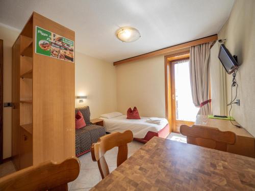 una camera con tavolo e una camera con letto di Residence Livigno MyHolidayLivigno a Livigno