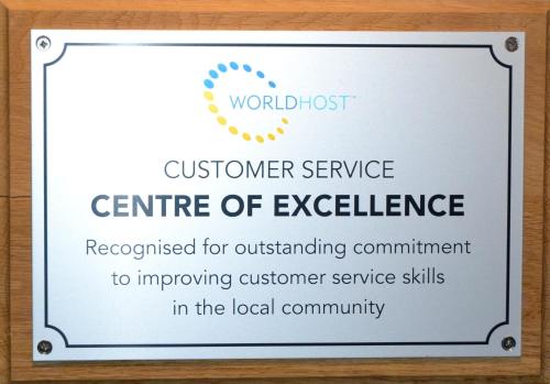 a sign that says customer service centre of excellence at Mackays Hotel in Wick