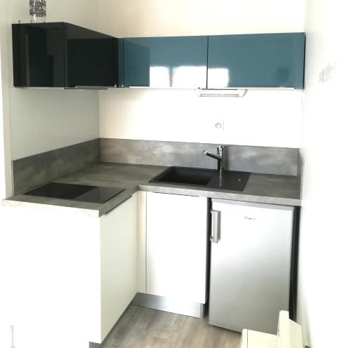 a kitchen with black and white cabinets and a sink at Appartement 4 couchages, 100 mètres de la mer ! in Les Sables-dʼOlonne