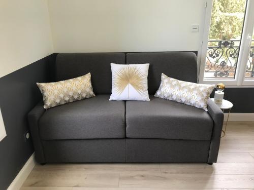 a couch with two pillows on it in a room at Domaine de Selhac in Frontignan