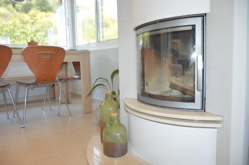 a living room with a fireplace and a table with chairs at Villa Kristi in Loutrá Elevtherón