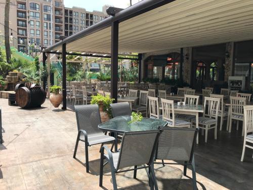 a patio with a table and chairs and tables and chairs at Oleander House and Tennis Club in Sunny Beach