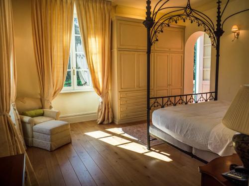 a bedroom with a canopy bed and a window at Hotel Villa Casanova in Lucca