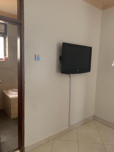 a flat screen tv on a wall in a room at Trendy apartments in Entebbe