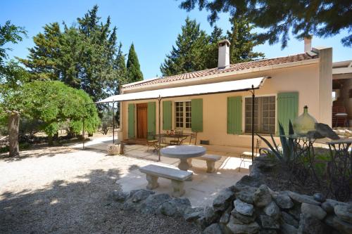 a house with a table and a bench in front of it at les mazets de la reine Pédauque in Paradou