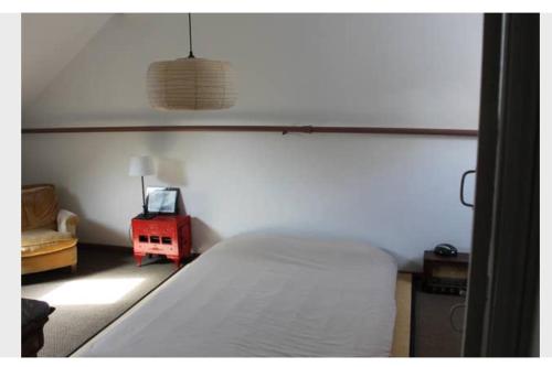 une chambre avec un lit et une table rouge dans l'établissement Maison centre-ville avec jardin Blois-Chambord, à Blois