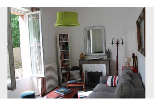 un salon avec un canapé et un miroir dans l'établissement Maison centre-ville avec jardin Blois-Chambord, à Blois