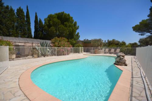 a swimming pool in a yard with a fence at les mazets de la reine Pédauque in Paradou