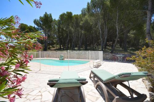 a patio with two chairs and a swimming pool at les mazets de la reine Pédauque in Paradou