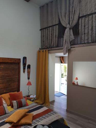 a bedroom with a bed and a yellow curtain at Le Clos d'Any in Fontet