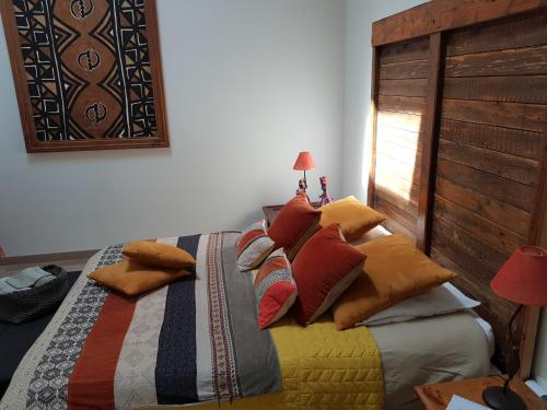 a bedroom with a bed with colorful pillows on it at Le Clos d'Any in Fontet