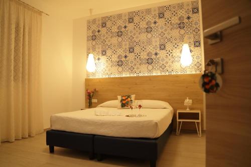 a bedroom with a bed with a floral wall above it at Terra d'amare in Castelluzzo