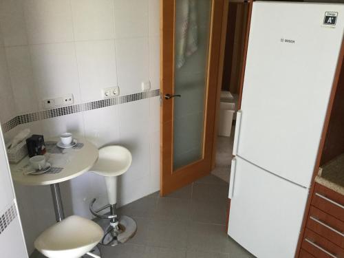 uma pequena cozinha com uma mesa, um lavatório e um frigorífico em Apartamento Vila Park em Cala de Finestrat
