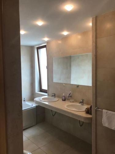 a bathroom with two sinks and a tub and a mirror at Sun Village Villa 6 in Byala
