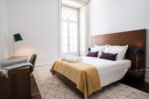 波多的住宿－D'Autor Apartments Alegria，一间卧室设有一张大床和一个窗户。