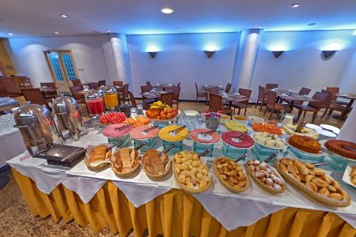 Una mesa con muchos tipos diferentes de comida sobre ella. en Hotel Shelton, en Serra Negra