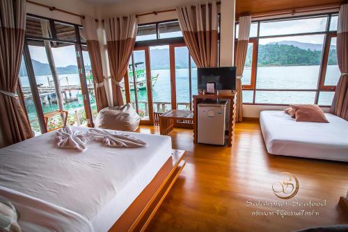 two beds in a room with a view of the water at Salakphet Resort in Ko Chang
