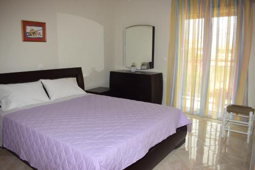 a bedroom with a large bed and a mirror at Mary's apartments close to the sea in Agios Georgios