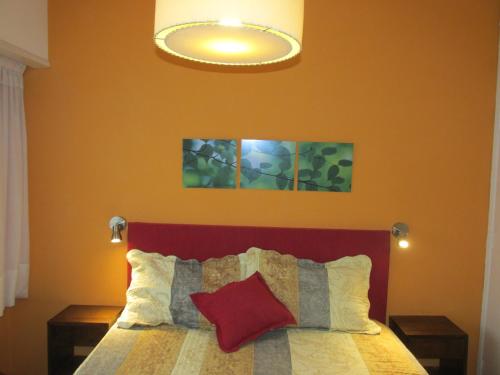 Schlafzimmer mit einem Bett mit rotem Kopfteil in der Unterkunft Cerca de Todo in Miramar
