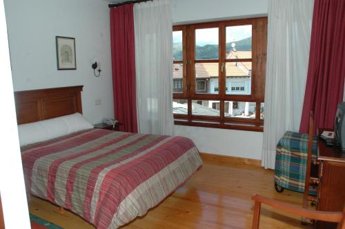 a bedroom with a bed and a window at Hotel Rural El Texu in Arriondas