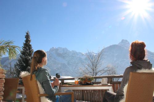 two women sitting at a table looking out at the mountains at Hotel Pfleger in Anras