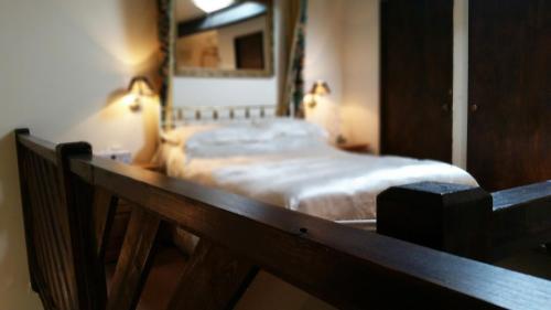 a bed in a bedroom with a wooden rail at Miltons Country Lodge in Langford