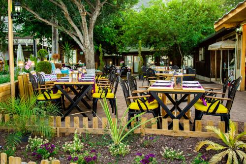 um restaurante com mesas de madeira e cadeiras amarelas em Kara Kedi Beach Bungalow em Cirali
